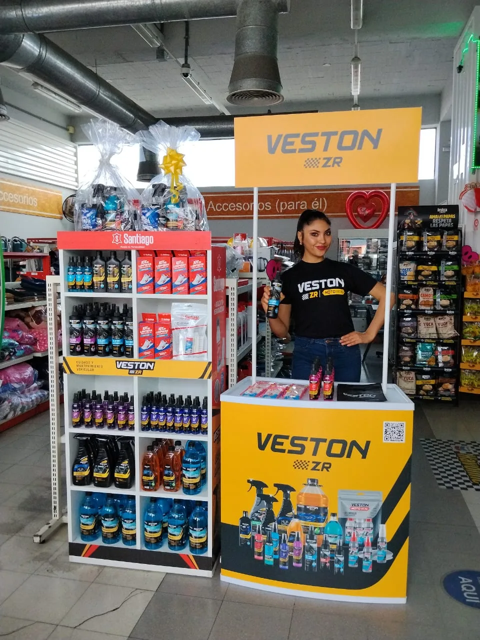 Promotora de Veston ZR en stand dentro de tienda con exhibidor de productos